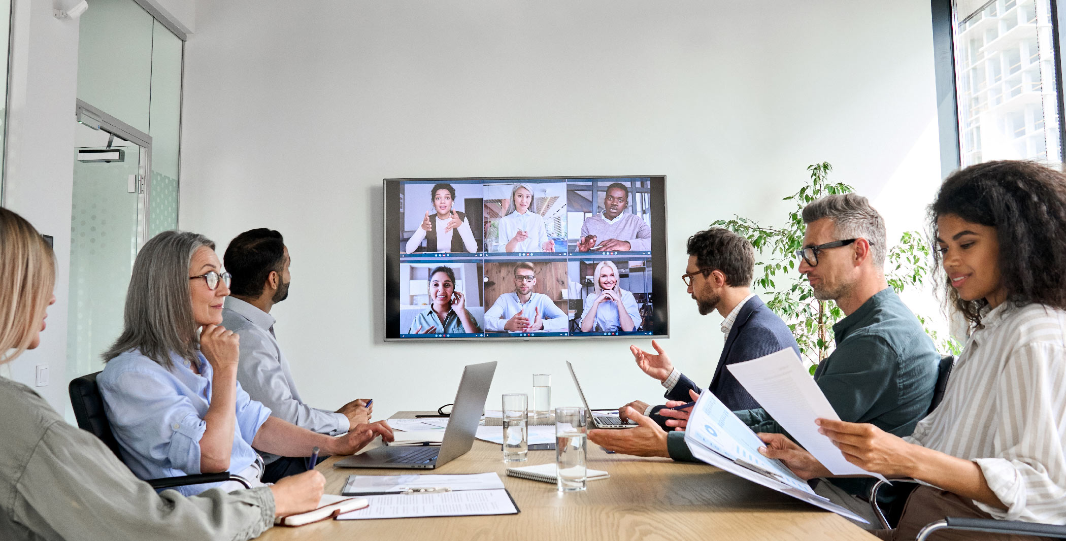 multiple people sitting at table discussing on zoom call